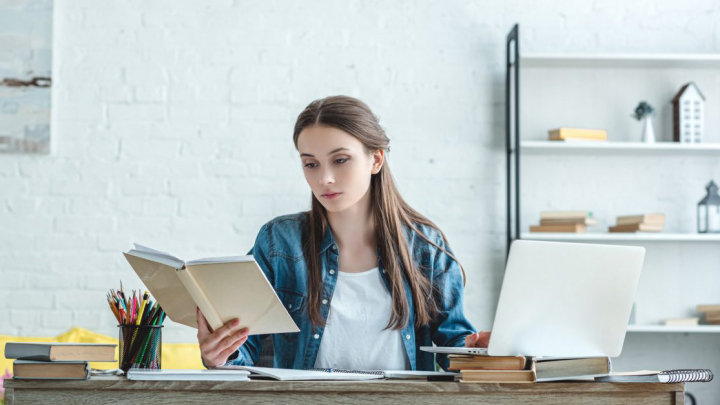 Ілюстрація: дівчина з книжкою за ноутбуком